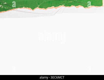 Green paper with torn edges, revealing a brown backing, covered with clear tape, on a white background Stock Photo