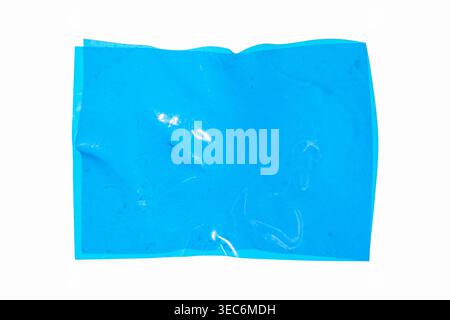 Blue plastic sheet with creases and transparent reflections, creased blank page on a white background, creating an abstract texture Stock Photo