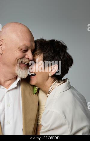 Two seniors express their deep affection through laughter and closeness, creating a warm connection. Stock Photo