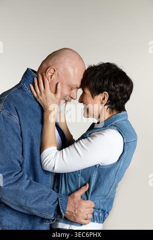 Two seniors embrace warmly, their foreheads touching as they express love and joy. Stock Photo