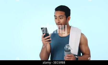 Fitness, phone and surprise with man in studio for gym membership discount, news or chat. Health app target, wellness goals and space with person on Stock Photo