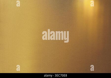 Golden brushed metal surface showing abstract texture. Light reflecting creating a shimmering effect, slight grain noise effect Stock Photo