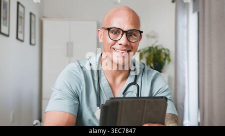 Smiling Doctor Using Tablet For Telemedicine Consultation In Home Office Setting Stock Photo