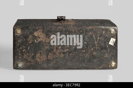 Casket, plant decoration, shields, dates, geometric ornament, early 16th century, possibly France, Flanders, or Germany; piece of furniture; height 12 cm, width 26.5 cm, depth 12.5 cm., A rectangular box shown from the front and top with a weathered dark brown to black surface and worn lighter brown patches, featuring incised decorative lines and carved star-like shapes; the box has a hinged clasp on top and rounded corners with several circular metal fittings that appear brass or bronze with greenish patina; a small light-colored rectangular paper tag is attached near one corner; the Stock Photo
