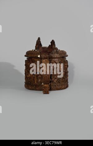 Wooden tankard, carved, probably a peg tankard, Religious/Gospel scenes: Passion scenes in bas-relief around the body and a Resurrection of Christ scene on the lid. Inscriptions; human figures and figurative motifs., noted. Decorative art: wooden pear-shaped tankard, round, richly decorated; lid rim and handle decorated with plant motifs and masks, studded with ivory pins. Center has a row of vertically driven metal pegs placed at regular intervals the top two missing. 17th century, Scandinavia. Vessel. Height 23.5 cm; width 20.5 cm., An ornately carved round wooden container with a lid, Stock Photo