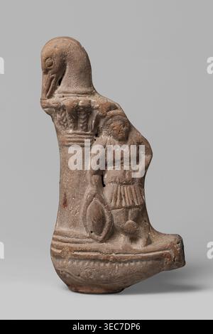 Lamp with a depiction of Athena-Neith, Lamp decorated with a youth, standing on its container, leaning against a column topped with a bird's head bent over a palm capital. The young man stands cross-legged, dressed in a garment that can be interpreted as a chiton or as Roman armor with pteryges, he has a Phrygian cap, on his head, and his right hand rests on a circular object a tambourine or rather a shield. Mithra mythology, Attys mythology, Phrygian caps iconography, figural lamps, Class.Gal.Scen., Athena mythology. 1st–3rd century, Egypt, oil lamp. Height 19.5 cm, width 9.7 cm, depth 4 cm., Stock Photo