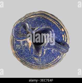 Oinochoe with a vertical arch-shaped vice; eastern workshop;, 3rd century BC Type: Grose group II:A, form II:3 Dark blue glass; on the belly threaded decoration in the form of horizontal and zigzag lines at the widest point of white and yellow glass. Trefoil rim; molding on the core Height: 8.90 cm Body diameter: 5.60 cm Outer diameter of the rim: ? cm Outer diameter of the bottom: ? cm Vessel, oinochoe, weight 0.076 kg, A top-down view of a rounded object with an irregular central opening, primarily deep blue with speckled lighter flecks, showing areas of worn tan or beige along raised edges Stock Photo