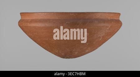 Medum type bowl, Medum type bowl with carination under the rim. Rim diameter smaller than the diameter of the shoulders. Rounded bottom. Straight, slightly flaring rim. Vessel made on the wheel of Nile clay, surface leveled. The bottom and lower part of the vessel finished to about half its height with a knife or similar tool. The surface of the vessel is covered with a layer of engobe . Vessel colour – red. c. 2686–c. 2181 BC; Old Kingdom, Edfu. Vessel; height 9 cm; diameter 21.1 cm rim, 21.5 cm shoulders., A large terracotta-colored ceramic bowl is shown from a side view against a neutral Stock Photo