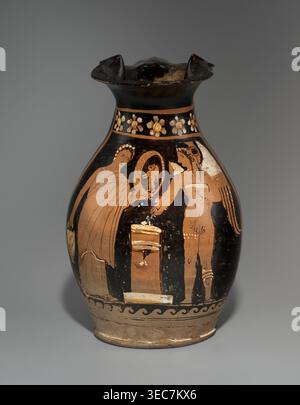 Red-figure oinochoe depicting a woman with a mirror and Eros, Apulia, late 4th century BC, vessel oinochoe, height 26.5 cm, width 17.5 cm, A ceramic vessel with a flared rim and rounded body sits against a neutral gray background; the vessel shows a palette of black, terracotta, beige, white, and hints of gold, with a band of floral motifs in light colors near the neck, a decorative wave pattern in dark and light near the base, and a painted scene on the bulbous body depicting a group of human figures in profile and three-quarter view, some draped in flowing garments, one holding a circular Stock Photo