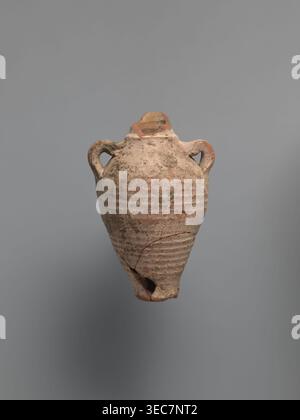 Water vessel qulla, bottle gulla. Ovoid, elongated body, wider in upper part, above half the vessel's height. Low foot, hollow inside, poorly defined externally. Two small vises are glued to the arms, and between them, on an axis perpendicular to their attachment, a conical spout for drinking water is glued. The neck, preserved in its lowest part, is separated from the body by a small, sharply profiled hump. The entire surface of the vessel is covered with light whitewash. Nile clay, medium-porous, 5th century, Tell Atrib, vessel; height 17.0 cm, width 11.5 cm, diameter 4 cm base., An aged Stock Photo