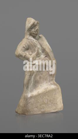 Terracotta gladiator figurine, unknown Southern Italian workshop, terracotta, male figurines. Figure of a gladiator ready for battle on a high base. Legs wide apart, left leg bent, right leg straight. Greaves reaching above the knees. In his right, bent hand he holds a dagger, and in the other a four-sided shield. Dressed in a short draped tunic and wearing a helmet. The Latin inscription PACILI is visible on the reverse of the base. Preservation: part of the base filled with plaster, partial shield and back of the head broken off, reflections, cracks. Date: 2nd–1st century BC. Place of origin Stock Photo