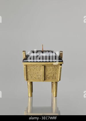 Fangding incense burner with cover, Paderewski, Ignacy Jan 1860–1941, Chinese art, Chinese culture, Qing dynasty 1644–1911, ceremonial vessel decorated with taotie and fantastic creatures, walls decorated with archaic ornament in flat relief, 19th century, China; vessel; height 15.2 cm, width 14.0 cm, depth 10.9 cm, A small rectangular vessel with a domed lid sits on four straight legs; the vessel body and legs are metallic gold with decorative raised patterns, and the lid is dark black with a short vertical finial in a brownish tone on top; the background is a smooth neutral gray and the Stock Photo