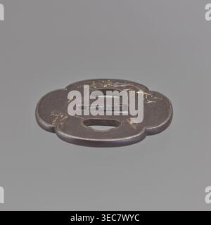 Crossguard tsuba, sword crossguard, landscape motifs depicting fishermen, bridges, rocks, and plants; plastic decoration: obverse — fisherman sitting by the water against a landscape background; reverse — landscape. 19th century, Japan European copy. Tsuba; height 6.9 cm, width 6.3 cm, depth 0.4 cm., A flat, rounded metal object with a cloverlike outline, shown against a neutral gray background, with a dark brown to black patina and areas of worn gold-colored highlights, featuring two elongated oval openings and a central rectangular slot, smooth edges, and subtle surface scratches and worn Stock Photo
