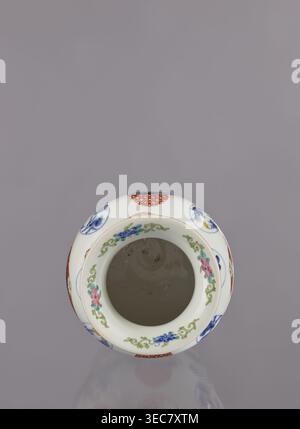 Vase by Tashiro, Japanese, colored porcelain, ceramics; Meiji period 1868–1912, 2nd half of 19th century. Hizen Arita, Japan. Height 28.5 cm, diameter 19.0 cm. Decoration: figurative scenes with landscape background, peonies, camellias, wisteria, fish, pine trees, asanoha pattern; genre scenes. Provenance unknown., A white ceramic vessel viewed from above with a round open mouth, decorated around the rim with a floral garland in green, pink, blue, and teal, and additional circular motifs in red and blue on the outer surface; the interior appears plain and light grayish, and the background is a Stock Photo