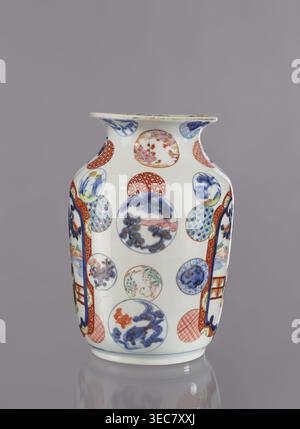 Vase, Tashiro maker/trading company, Japanese, colored porcelain, ceramics, Meiji period 1868–1912, 2nd half of 19th century. Hizen, Arita, Japan. Height 28.5 cm; diameter 19.0 cm. Decoration: figurative scenes with landscape background, peonies, camellias, wisteria, fish, pine trees, asanoha pattern. Provenance unknown., A white ceramic vase decorated with a pattern of round medallions and vertical panel shapes, featuring painted scenes and motifs in blue, red, green, pink, and gold tones, with a flared rim and a gently tapered body standing on a short base, set against a plain gray Stock Photo