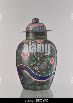 Vase with cover, Japanese, cloisonné enamel, dragons and plant ornament, Japanese dragon motif, geometric-plant ornament combining shippo, kikko, and asanoha patterns, Meiji period ca. 1860–1870; Man'en 1–Meiji 3, Edo 1603–1868 influences, Man'en 1860–1861, vessel, height 57.0 cm, A lidded rounded vessel with a bulbous body and a flat-rimmed lid sits against a plain light gray background; the vessel displays an intricate overall pattern in dark green, deep blue, pink, red, white, yellow, and gold, including floral motifs, small geometric patches, and a sinuous dragon-like form in dark blue Stock Photo