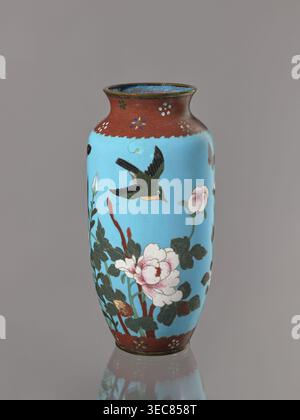 Vase, Cloisonné enamel on copper with brass rims at the spout and foot. Decoration: large roses and lilies, small flowers, two birds and a butterfly on a blue background kachôga. Short, slightly flared neck. Japanese, Meiji period ca. 1905–1908. Vessel. Height 30.8 cm; diameter 10.6 cm., A tall vase with a glossy sky-blue body and a narrow neck rimmed in a reddish-brown band decorated with small floral motifs, featuring a painted scene of a green and black bird in flight above a cluster of dark green leaves and pale pink peony-like blossoms with reddish stems; the interior of the rim shows a Stock Photo