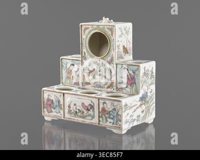 Pedestal for a writing set three-stage, gift, repossession Krakow, ceramics decorated with flowers, figural scenes, butterflies and landscape motifs in colored porcelain, Qing style late 19th century, Qing 1644–1911, Chinese, raised central part, writing accessories, height 18.9 cm, width 17.9 cm, depth 11.0 cm, A small multi-tiered ceramic object with a glossy white base decorated in painted scenes and floral motifs in colors including pink, green, blue, brown, yellow, and black. The piece has a stepped rectangular form with a circular opening near the top and several circular recesses on a Stock Photo