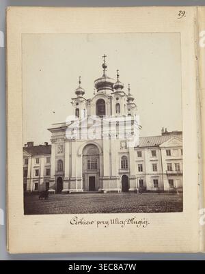 The Church at Długa Street the Piarist Church rebuilt into an Orthodox Church, Beyer, Karol 1818–1877 author/photographer, Méyet, Leopold 1850–1912, Piarist Church Długa Street, Warsaw, Trinity Church St. Trinity Church, Długa Street Warsaw, Orthodox churches, domes, 1861–1863, photography, nature photography, photographic print: 8.3 × 7.4 cm; support: 11.3 × 8.8 cm, A sepia-toned photograph mounted on an off-white page shows a large ornate building with a tall central facade and several onion-shaped domes topped with crosses. The facade features arches, columns, decorative moldings, and Stock Photo