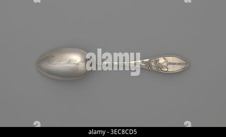 Souvenir spoon by Towle Silversmith fl. 1882–, late 19th century. Ovoid dipper with pointed tip showing a scene of a mine interior with two men with pickaxes; reverse of dipper engraved in cursive Batle Mont probably referring to Battle Mount, Nevada. Straight, flaring handle with lanceolate tip; handle grip depicts a man standing by a well, turning a crank, winding a chain along the handle to which a bucket filled with ore is attached, reaching into the mine. Reverse of handle shows a crossed shovel, pickaxe and a rope with an incomprehensible inscription. Souvenir spoon, cutlery; materials: Stock Photo