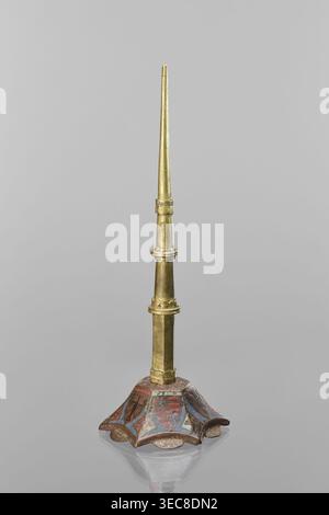 Candlestick, enamel; on a hexagonal base tapering toward the top with a shaft; on each side a coat of arms on a blue enamel background eagle and blue lion on horizontal red stripes; between them below the shields on the edges rhombuses with engraved dragons. 19th-century shaft, 14th century Limoges, Barcelona, lighting; height 32 cm, diameter 11 cm., A slender vertical object with a pointed top in a metallic gold color rises from a decorative base; the shaft shows a few segmented collars and cylindrical sections in varying gold tones with subtle darker patina. The base is flared and scalloped Stock Photo