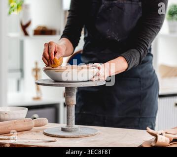 Close-Up Of Woman's Hands Making Clay Plate In Ceramics Workshop Stock Photo