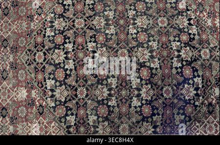 Carpet, Knotted woolen fabric, woven carpet, 2nd half of the 19th century, Iran. In the center are four nested hexagonal medallions. Their interiors and the remaining small background area are filled with motifs of flowers, lanceolate leaves, and rosettes surrounding rhombuses. Three-band border with floral motifs. Colors: multiple reds, cream background, blue ornament. Height 667 cm, width 415 cm., A patterned textile filling the frame with a dense arrangement of geometric and floral motifs in a muted palette, showing shades of red, dark blue, beige, cream, and touches of olive green and Stock Photo