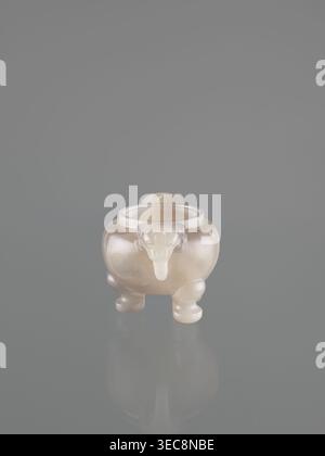 Ding-type incense burner with cover; lions; ceremonial vessels; fo; incense burners; Chinese art; China; 20th century; decorative vessel; height 12.0 cm; width 11.0 cm; depth 7.5 cm, A small translucent pale object with a smooth, glossy surface sits centered against a muted gray background, appearing slightly reflective on the surface beneath it; the object has a rounded body supported by a few short, curved legs and a protruding spout-like feature on one side, with soft gradients of creamy white and faint beige tones across its form and a subtle shadow and reflection on the gray surface. Stock Photo