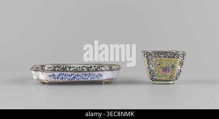 Bowl with saucer; painted enamel on porcelain; subject: plant ornament with peonies and plant tendril; Chinese, Qing dynasty (1644–1911), 18th century; maker: unknown; inscribed/associated name: Paderewski, Ignacy Jan (1860–1941) (ownership or association noted); function: vessel; dimensions — bowl: height 3.4 cm, width 4.7 cm; saucer: length 9.7 cm, width 9.7 cm., A shallow rectangular dish with a scalloped rim sits next to a small flared cup; the dish is predominantly white with blue floral-like painted motifs along its sides, a dark decorative band along the inner rim, and small raised feet Stock Photo