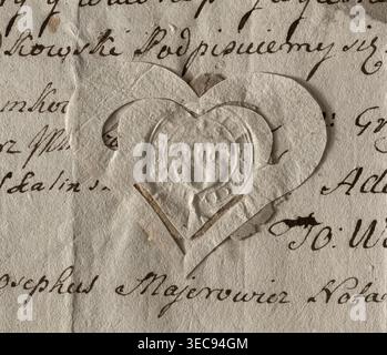 Round seal impression of the town of Szadek. City wall with a gate and battlements, three towers with windows. Above them an illegible structure. Inscription around the rim: * SIGILLUM * CIVITATIS * S, 1782, Poland, seal., A textured beige paper background with visible creases and a faded handwritten script partially visible beneath; layered on top is a cutout heart shape made from similar textured paper, with a smaller heart cutout centered inside and an embossed circular pattern in the middle; colors visible include shades of beige, off-white, brown, and hints of darker brown in the inked Stock Photo