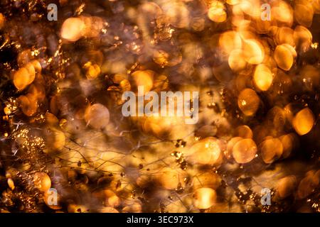 Golden nano background in metallic texture. Golden nano shimmer on glossy surface. Golden nano gold flakes for luxury art. Golden nano reflective Stock Photo