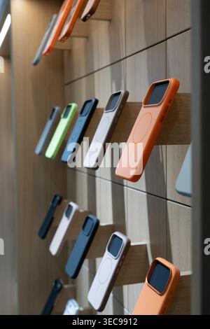 A Showcase of Colorful Phone Cases Arranged on a Wooden Display Wall, Highlighting Various Designs and Textures for Modern Smartphones Stock Photo