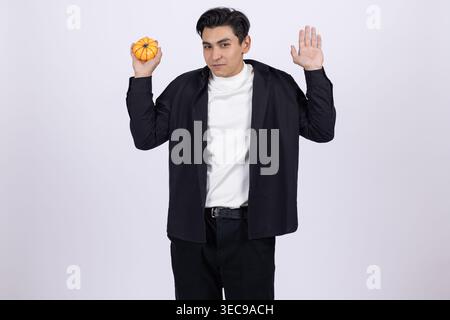 Surprised young man holding a donut and looking away in shock Stock Photo