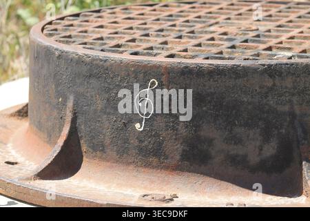 Treble Clef Drawn On Rusty Manhole Cover Stock Photo