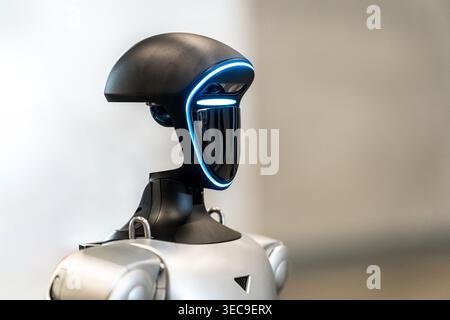 Modern humanoid robot head featuring sleek design and illuminated blue facial details, symbolizing advanced artificial intelligence in technology Stock Photo