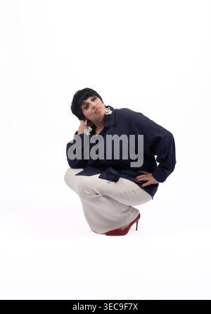 Confident man in dark clothes sitting on the floor Stock Photo
