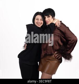 Two happy women hugging and smiling together in studio Stock Photo