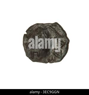 Bronze coin, Pantikapaion; obverse: bearded Satyr's head to the right, countermark (tripod and inscription on the left); reverse: bow and arrow to the right, inscription below; iconography: Satyr's head, tripod countermark, bow and arrows; countermarks (numism); weapons (iconographic); Satyr (mythology); ca. 250 BC; Cimmerian Bosporus, Pantikapaion; coin; weight 3.40 g; dimensions 15.5 mm × 17.6 mm., A small round object with an irregular edge, dark brown to black in color with lighter brown and greenish patches, showing a worn, uneven surface texture with shallow raised areas and depressions; Stock Photo