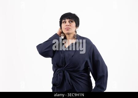 Mature woman in dark blue shirt touching her face Stock Photo