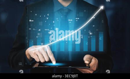 Businessman interacts with tablet displaying financial data and upward trends. Modern digital interface enhances analysis that drives business decisio Stock Photo