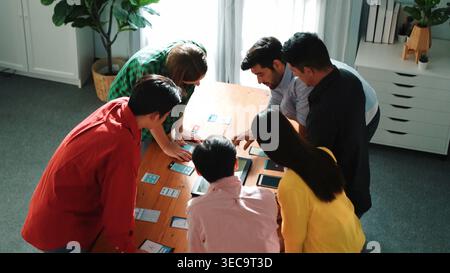 Top view of diverse business people discussing idea and designing system while using tablet with Ux, Ui design display on screen. Multicultural workin Stock Photo