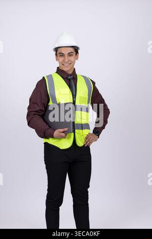 Worker in safety vest and hard hat standing still Stock Photo
