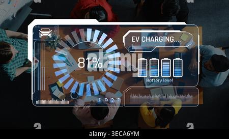 Aerial view of a group engaged in an electric vehicle charging experience, featuring a digital dashboard displaying battery levels and charging progre Stock Photo