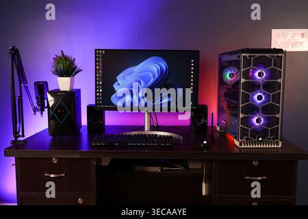 A Windows 11 Desktop PC Setup in a dark background, this is a High End Gaming or Editing Computer with RGB Lights. A Perfect studio or Office Interior set. Stock Photo