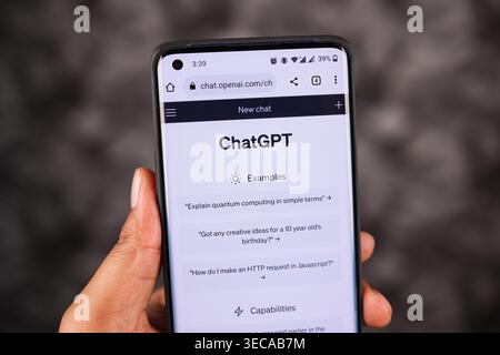 Closeup of ChatGPT screen on Phone in White Mode holding with left Hand in a dark Background, Browsing ChatGPT on a Smartphone screen. Stock Photo