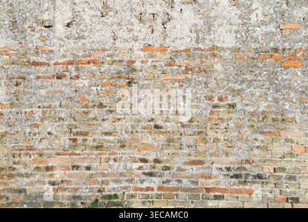 Old weathered brick wall background providing a textured architectural surface suitable for design and background use. Stock Photo