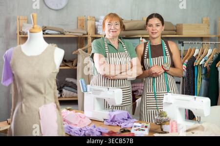 Female dressmakers standing in the workshop near the table Stock Photo