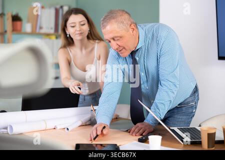 Engineer and architect discussing about blueprint layout design of electricity plan before construction in office Stock Photo