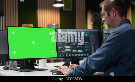 Green screen PC used by Silicon Valley company developer in office developing apps. Worker using deep learning tech on chroma key computer at work to debug applications and resolve issues Stock Photo
