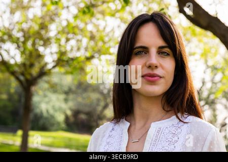 Young woman smiling in serene park environment Stock Photo